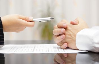 man signing documents