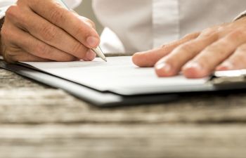 man signing documents