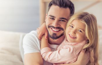 Happy dad cuddling his little daughter.