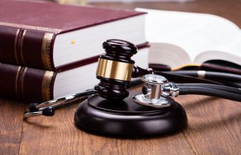 A stethoscope and judge's gavel on a medical malpractice attorney's desk.