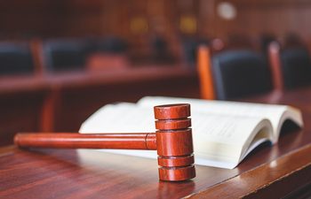 judges gavel and open legal book on a desk in a courtroom